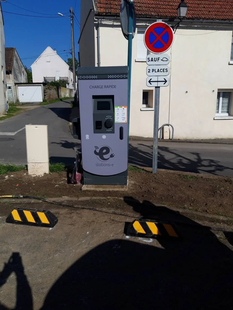 Borne charge rapide Stations-e livrée en pleine rue avec signalisation