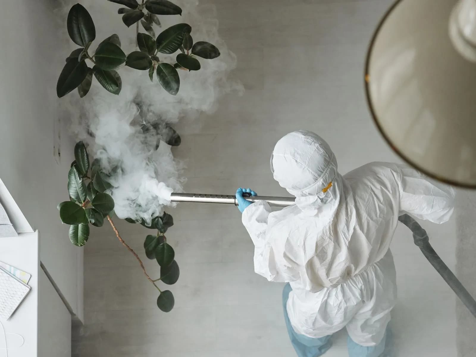 Technicien en combinaison réalisant une fumigation en intérieur