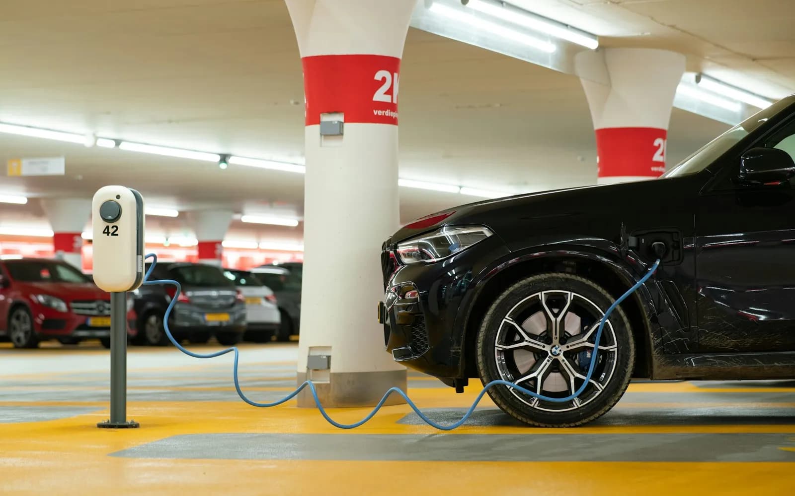 Véhicule électrique en charge sur une borne dans un parking